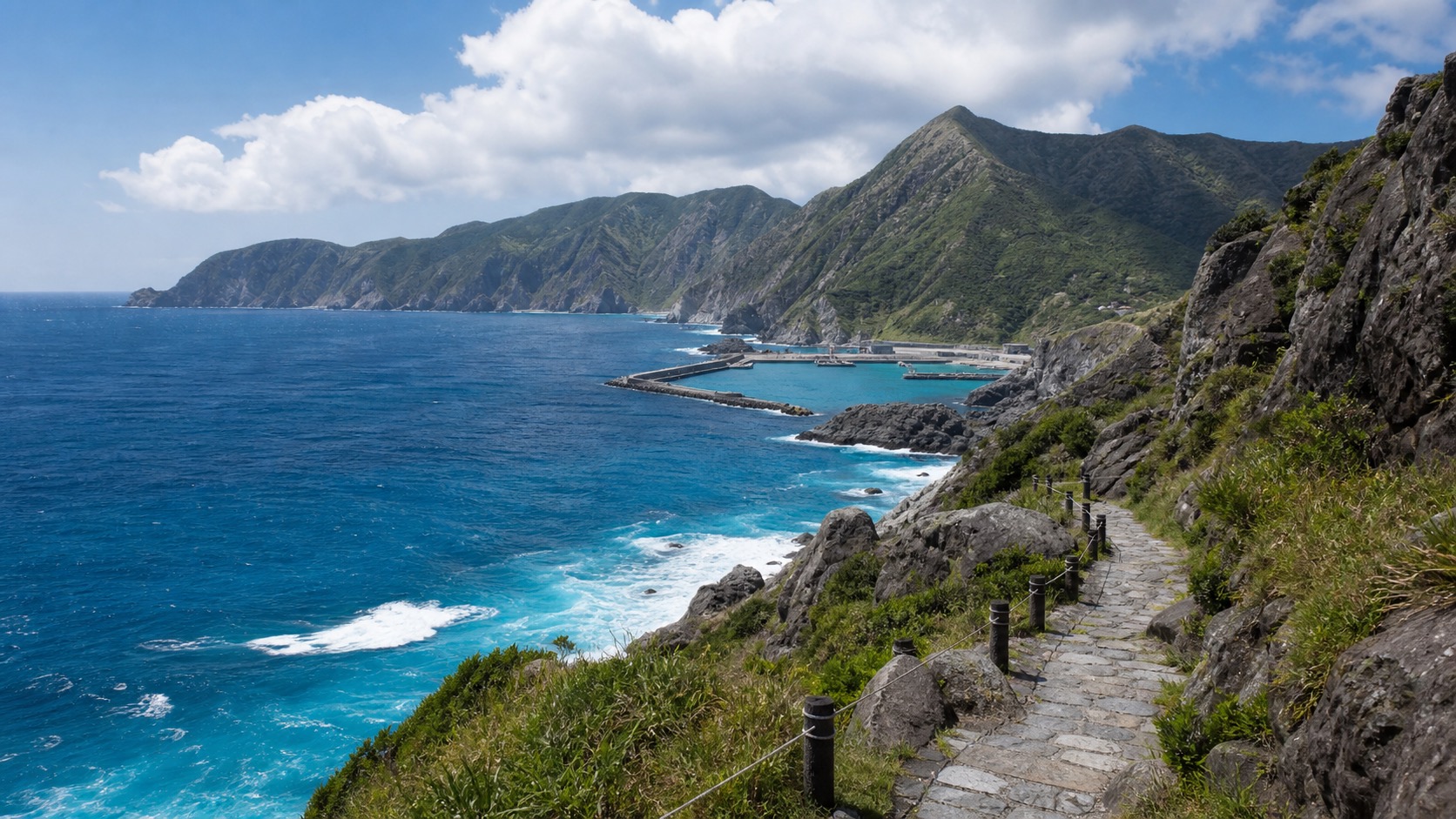 生成AIイメージ画像: 東京から神津島へ行く2泊3日モデルコース。神津島の海沿いの遊歩道と山影を思わせる週末島旅の雰囲気