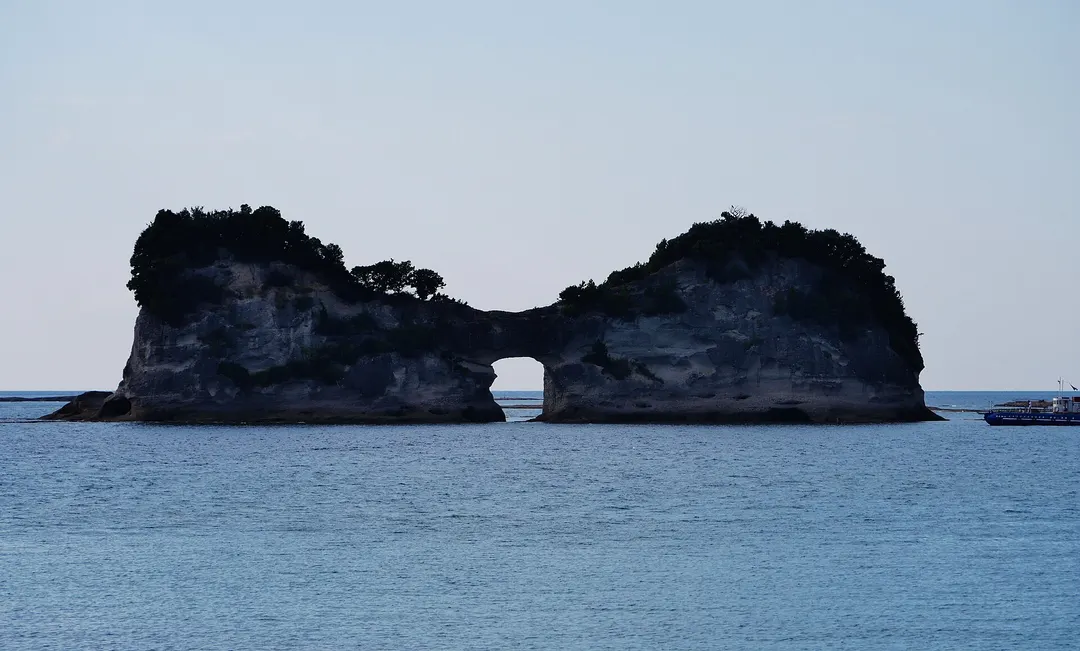 白浜の海上に浮かぶ円月島の海蝕洞を正面から写した実写写真