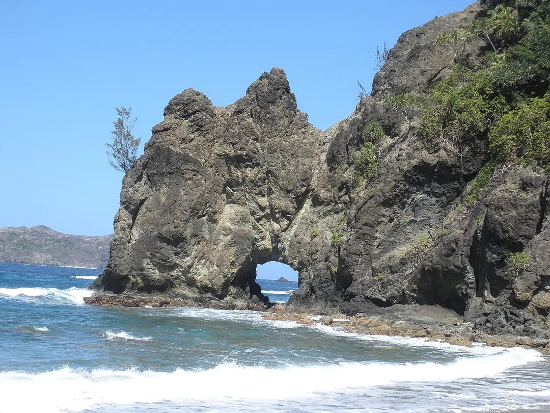 初寝浦の波打ち際にある穴の開いた岩。岩の穴や崖下を通る散策ルートとしては案内していません。