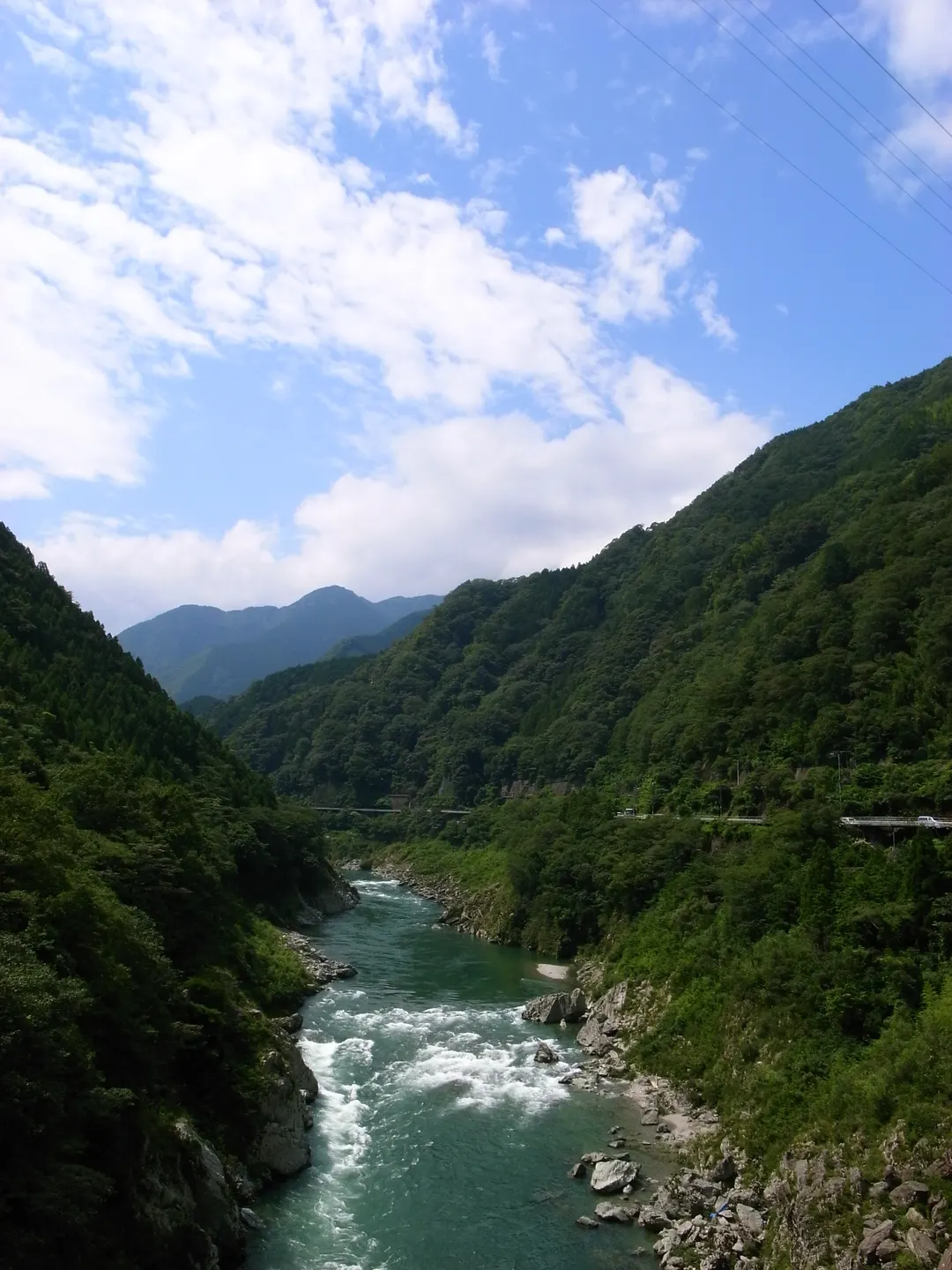 祖谷川が山間を流れる様子と谷沿いの道路を見渡した実写写真