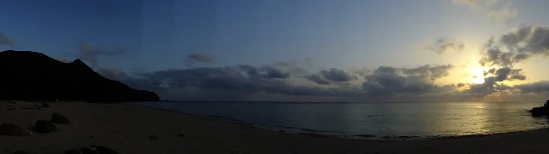 久米島・アーラ浜の海と岬を夕日の時間帯に横長で写した実写写真
