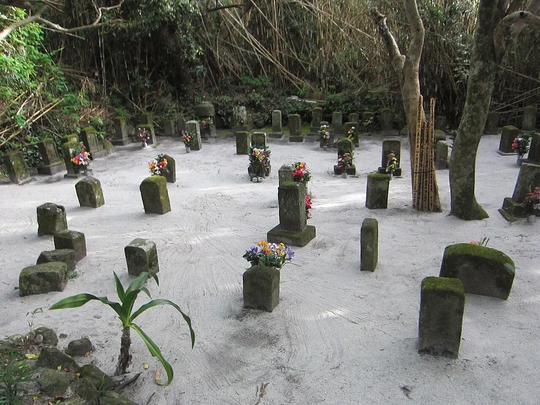 長栄寺に続く流人墓地の墓石と白砂を写した実写写真