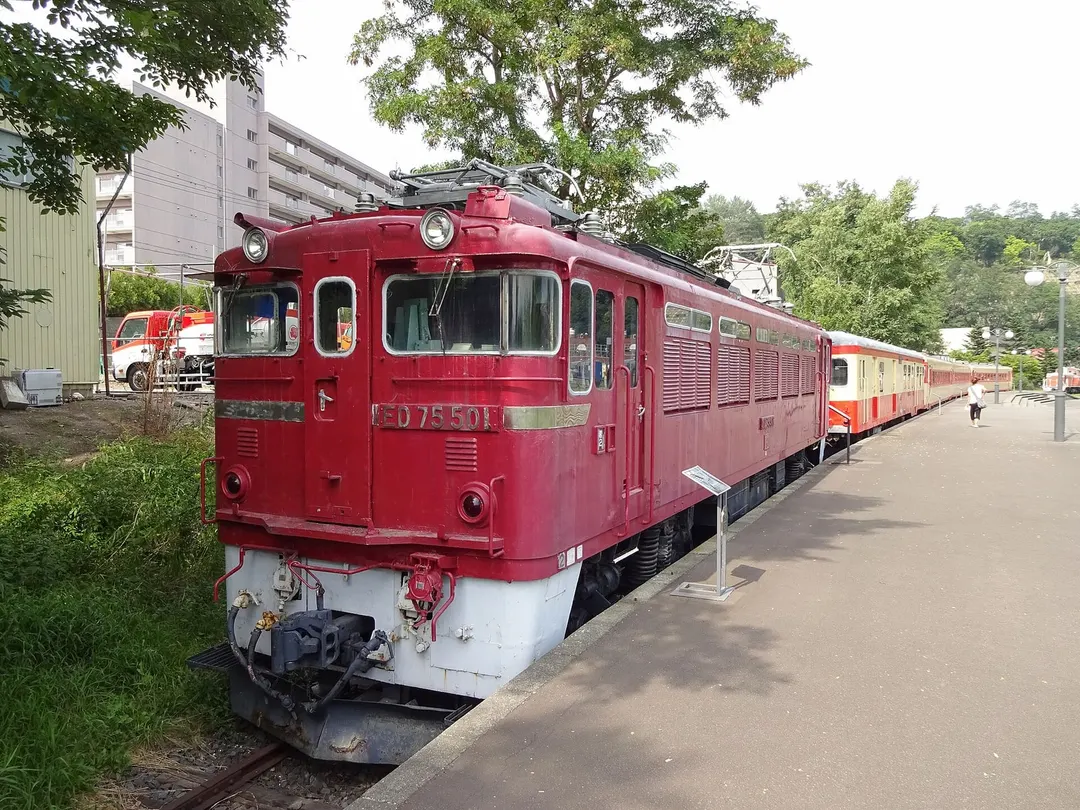 小樽市総合博物館の屋外に保存された赤い電気機関車ED75 501を写した実写写真