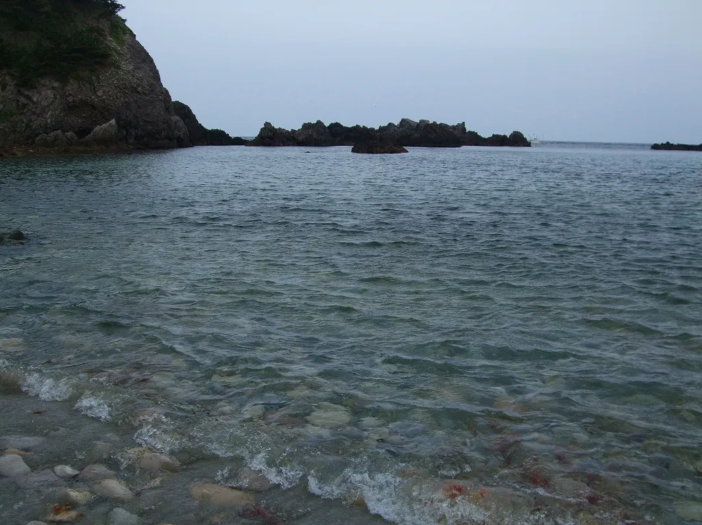 式根島・大浦海水浴場の入り江と海面を海岸から写した実写写真