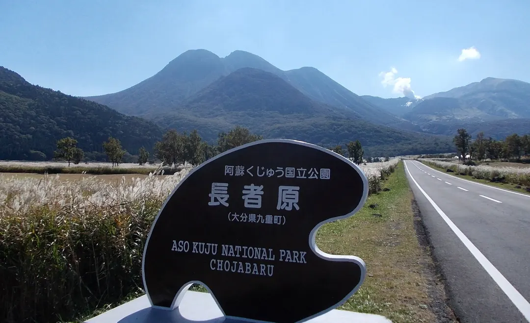 長者原からくじゅう連山を望み、タデ原湿原方面を案内する標識を写した実写写真