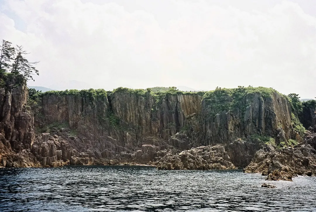尖閣湾揚島遊園から海上に連なる切り立った岩壁を写した実写写真