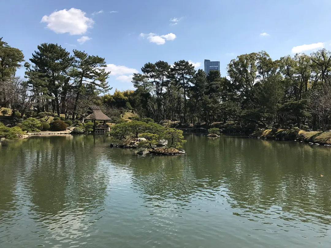 縮景園の濯纓池と池畔の木々、清風館を望む実写写真