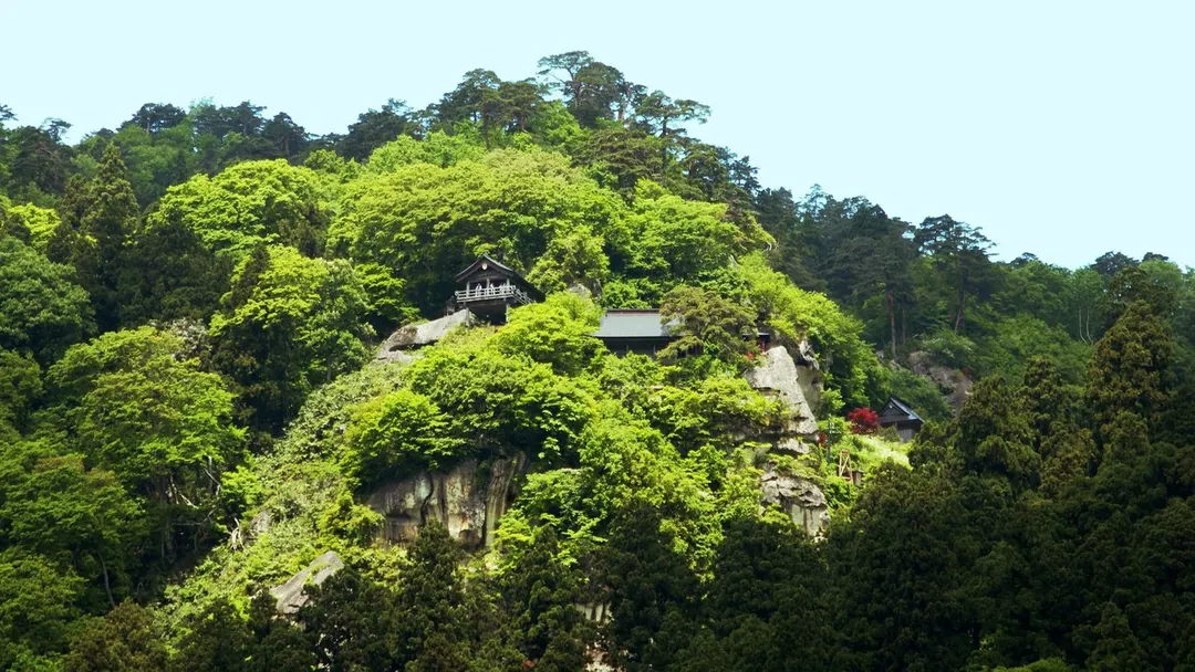 緑の山肌に五大堂・開山堂などが見える山寺の実写写真