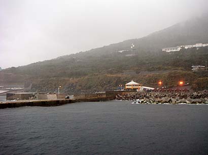 海側から利島港の岸壁と港湾施設を写した実写写真